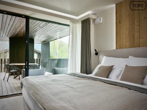 a bedroom with a large bed and a balcony at Haus am Lift - TOP2 - Summercard included - Ski-in Ski-out - 6P in Zell am See