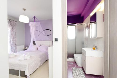 a bedroom with a white bed and a purple ceiling at Theros Lux Apartment in Émbonas