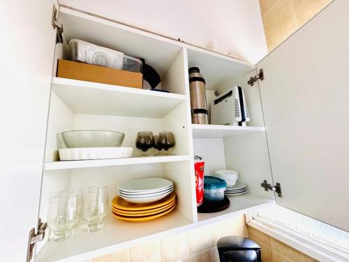 a kitchen pantry with plates and dishes on shelves at Departamento A Mar in Mar del Plata