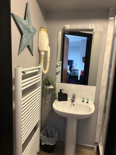 a bathroom with a sink and a mirror at Bay view rooms at Mentone Hotel in Weston-super-Mare