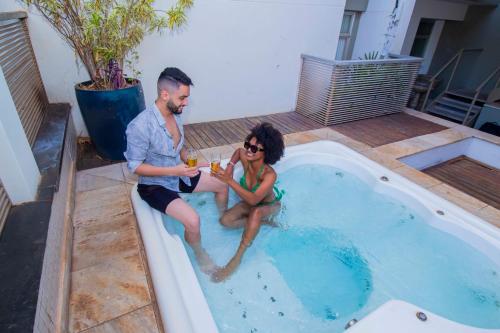 a man and a woman sitting in a swimming pool at Hotel Dan Inn São José do Rio Preto by Nacional Inn in Sao Jose do Rio Preto