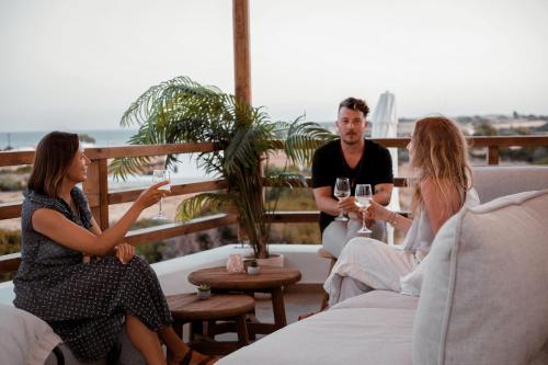 a group of people sitting on a balcony with wine glasses at CasaCarma V, privates XL-Pool, Boho-Design in Lachania