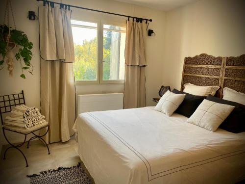 une chambre avec un grand lit et une fenêtre dans l'établissement Les Capucines, à LʼIsle-sur-la-Sorgue