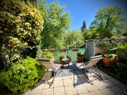 d'une terrasse avec des chaises et une table dans le jardin. dans l'établissement Les Capucines, à LʼIsle-sur-la-Sorgue