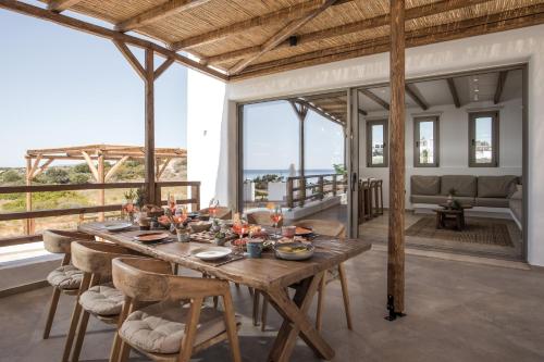 a dining room with a wooden table and chairs at CasaCarma V, privates XL-Pool, Boho-Design in Lachania