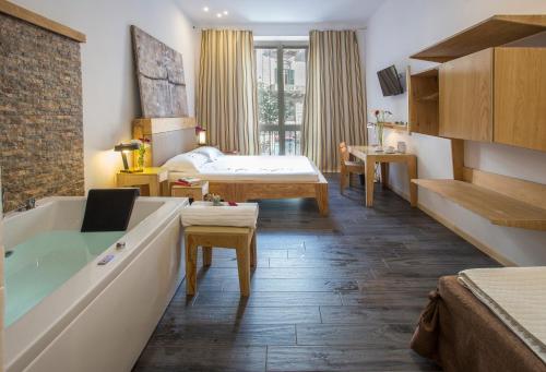 um quarto de hotel com uma banheira e um quarto em AQUAROOMS Luxury Suites em Palermo