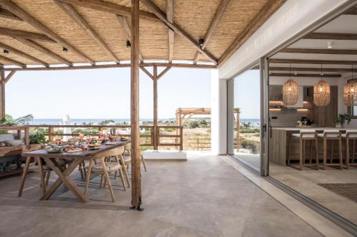 an open kitchen and dining room with a table and chairs at CasaCarma V, privates XL-Pool, Boho-Design in Lachania