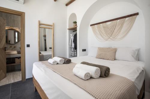 a bedroom with a white bed with towels on it at CasaCarma V, privates XL-Pool, Boho-Design in Lachania