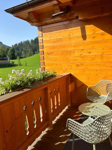 two chairs and a table on a wooden deck at Haus Annabelle in Wagrain
