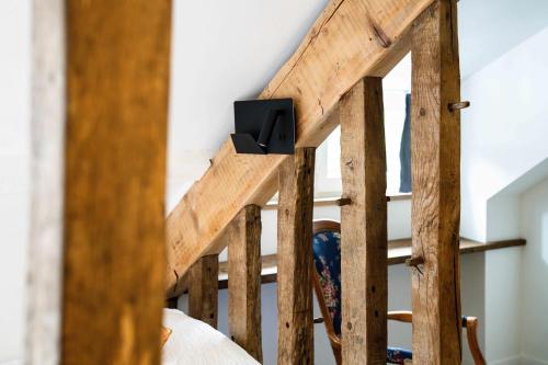 a wooden stair railing with a speaker on it at Logis Hôtel Etchemaïté in Larrau