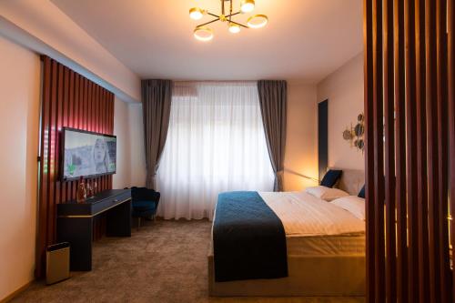 a hotel room with a bed and a window at Al Centro in Bucharest