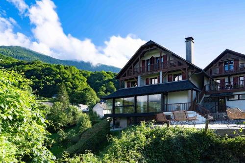 a large house with a view of a mountain at Logis Hôtel Etchemaïté in Larrau