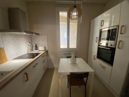 une cuisine avec un évier et une table à l'intérieur dans l'établissement LE Zen, à Nîmes