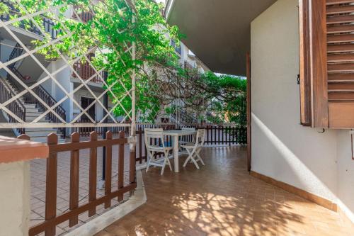 a balcony with a table and chairs and a fence at Italian Experience-Conero Garden Apartment in Marcelli