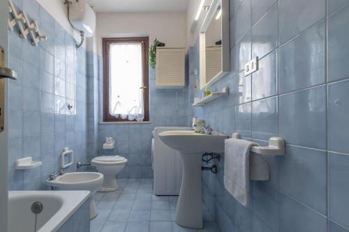 a blue bathroom with a sink and a toilet at Italian Experience-Conero Garden Apartment in Marcelli