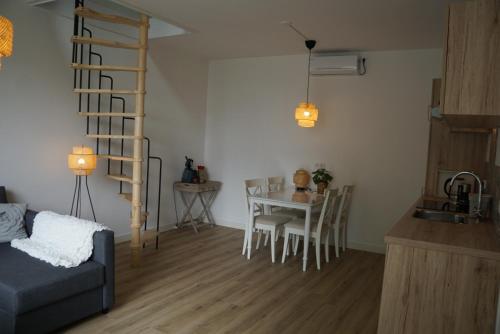 sala de estar con mesa y cocina con escalera en Vakantiehuis in de polder, en Lewedorp