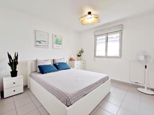 - une chambre blanche avec un lit et des oreillers bleus dans l'établissement Bright & calm sea-view apartment, à Antibes