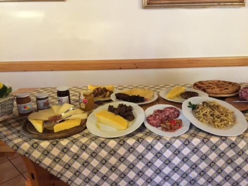 a table with plates of food on a table at Rifugio Pranolz in Trichiana