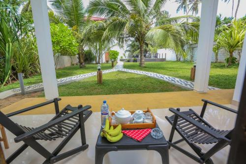 NetolpitiyaBlue Ocean Resort的门廊上的桌子上放着一盘食物和香蕉。