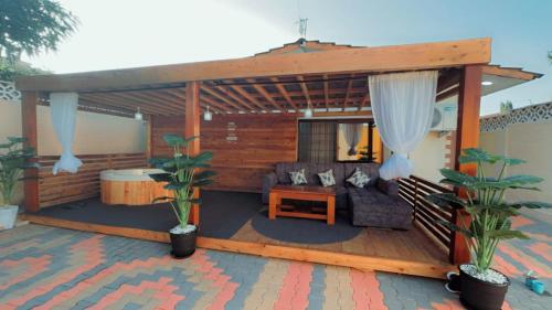 a wooden deck with a couch and a pergola at Royal Dutchess Luxurious Stay Bamburi in Bamburi