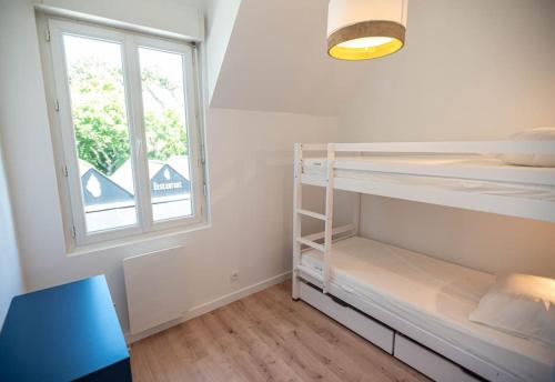 Cette petite chambre comprend des lits superposés et une fenêtre. dans l'établissement KER PIRAH Appartement proche des plages centre carnac plage, à Carnac