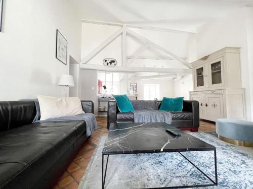 un salon avec un canapé noir et une table dans l'établissement Le Duplex Rétro, à Nantes