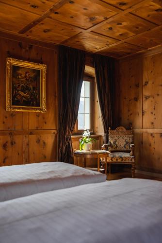a bedroom with a bed and a table and a window at Villa Carisch in Reams