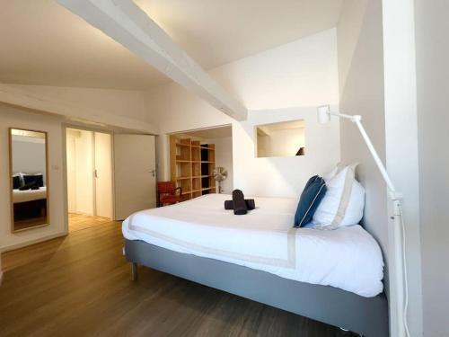 une chambre avec un grand lit blanc avec une lampe dans l'établissement Le Duplex Rétro, à Nantes