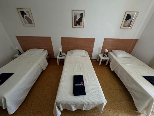 a room with three beds in a room at Pilar Hostel - Rua de Santa Catarina - Porto in Porto