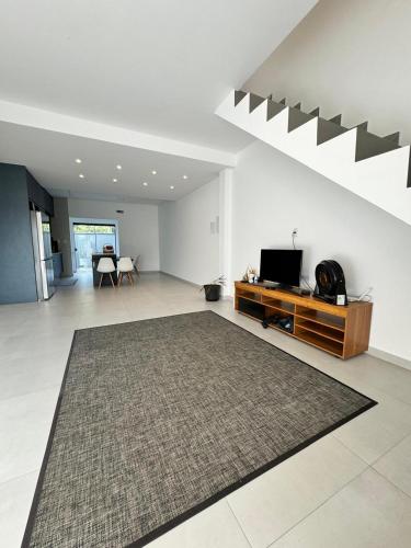a living room with a large rug on the floor at Lindo Sobrado em Camboriú in Camboriú