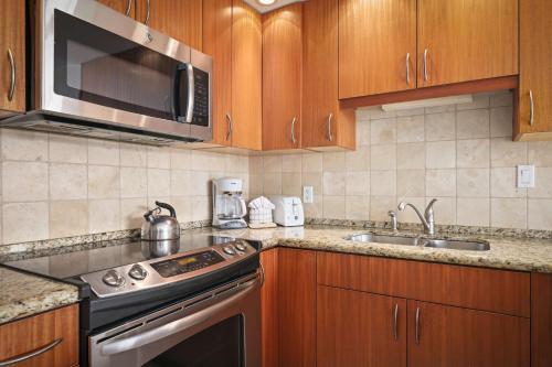 a kitchen with a stove and a microwave at Aston at Papakea Resort in Lahaina