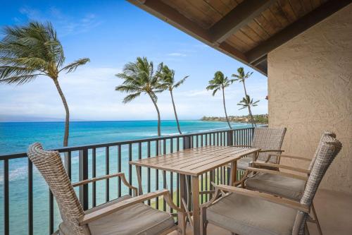 a balcony with a table and chairs and the ocean at Aston at Papakea Resort in Lahaina