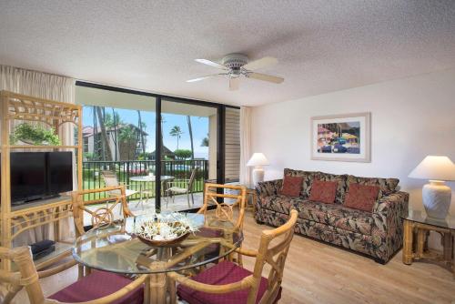 a living room with a couch and a glass table at Aston at Papakea Resort in Lahaina