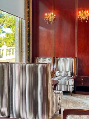 a living room with two chairs and a couch at GoldOne Hotel & Suites in Seogwipo