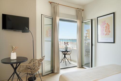 a bedroom with a bed and a table and a balcony at LAN Suites Antilla Playa in La Antilla