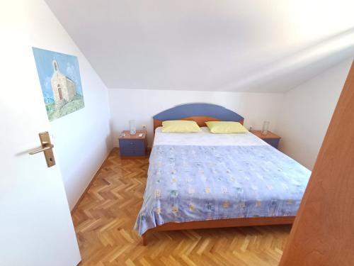 a bedroom with a bed with a blue bedspread at Apartmani Saška 2 in Privlaka