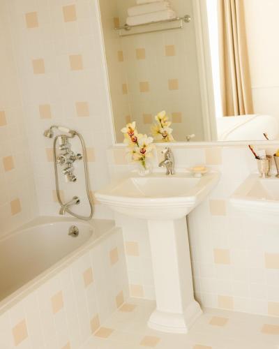 a white bathroom with a sink and a bath tub at LILOU in Hyères