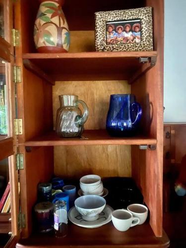 a wooden shelf with bowls and cups on it at Lakefront bungalow - Relaxation Plus in Santa Cruz La Laguna