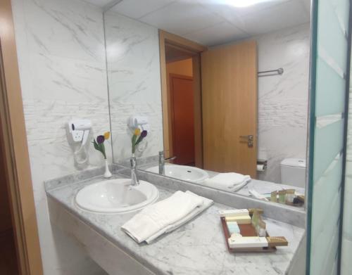 a bathroom with a sink and a mirror at York International Hotel in Dubai