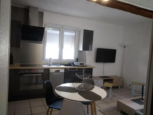 una cucina con un tavolo e sedie in una stanza di Appartement cosy a Saint-Laurent-de-la-Salanque