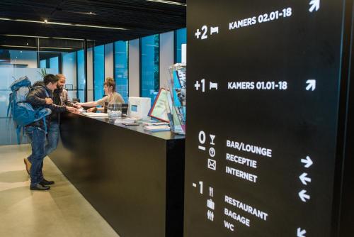 a group of people standing at a counter in a store at Antwerp Central Youth Hostel in Antwerp