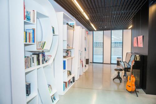 a library with white shelves filled with books at Antwerp Central Youth Hostel in Antwerp