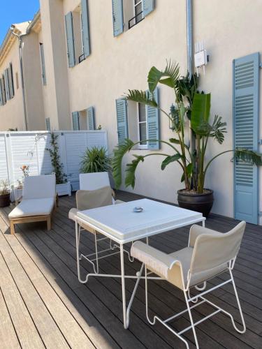 a white table and chairs on a deck at LILOU in Hyères