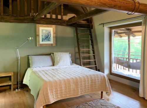 a bedroom with a bed with a ladder and a window at Affittacamere Montagne Verdi in Varallo