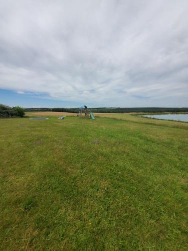 a grass field with a playground in the middle of it at Cabane des bois in Rouffignac Saint-Cernin