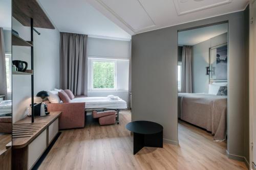 a hotel room with a mirror and a bedroom at Quality Hotel Edvard Grieg in Bergen