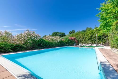 a swimming pool in a yard with trees at Italian Experience- Villa La Pagliarina in Cartoceto
