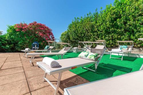 a row of chaise lounge chairs on a patio at Italian Experience- Villa La Pagliarina in Cartoceto