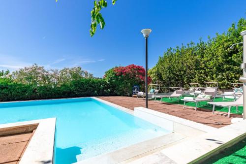 a swimming pool in a yard with chairs and a table at Italian Experience- Villa La Pagliarina in Cartoceto