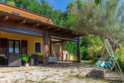 a patio of a house with a swing at Italian Experience- Villa La Pagliarina in Cartoceto